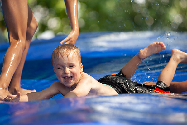Ein kleiner Junge hat Spaß und lacht auf der Wasserrutsche im Piratenland Neuwied
